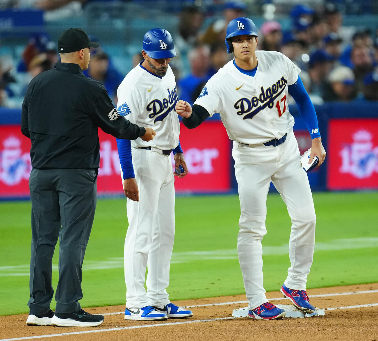 ドジャース対ダイヤモンドバックス　3回裏ドジャース1死、四球で出塁し一塁塁審からヒマワリの種をもらう大谷（右）（撮影・垰建太）