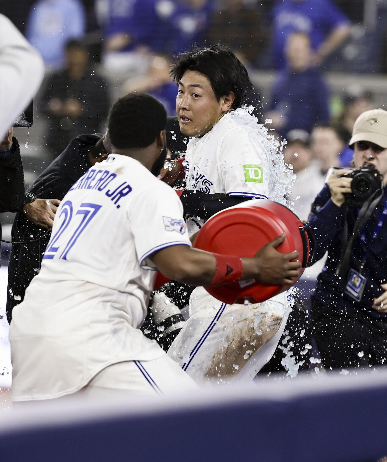 アスレチックス戦でサヨナラのホームを踏み、試合後にゲレロ（左）から手荒い祝福を受けるブルージェイズ岡本（共同）