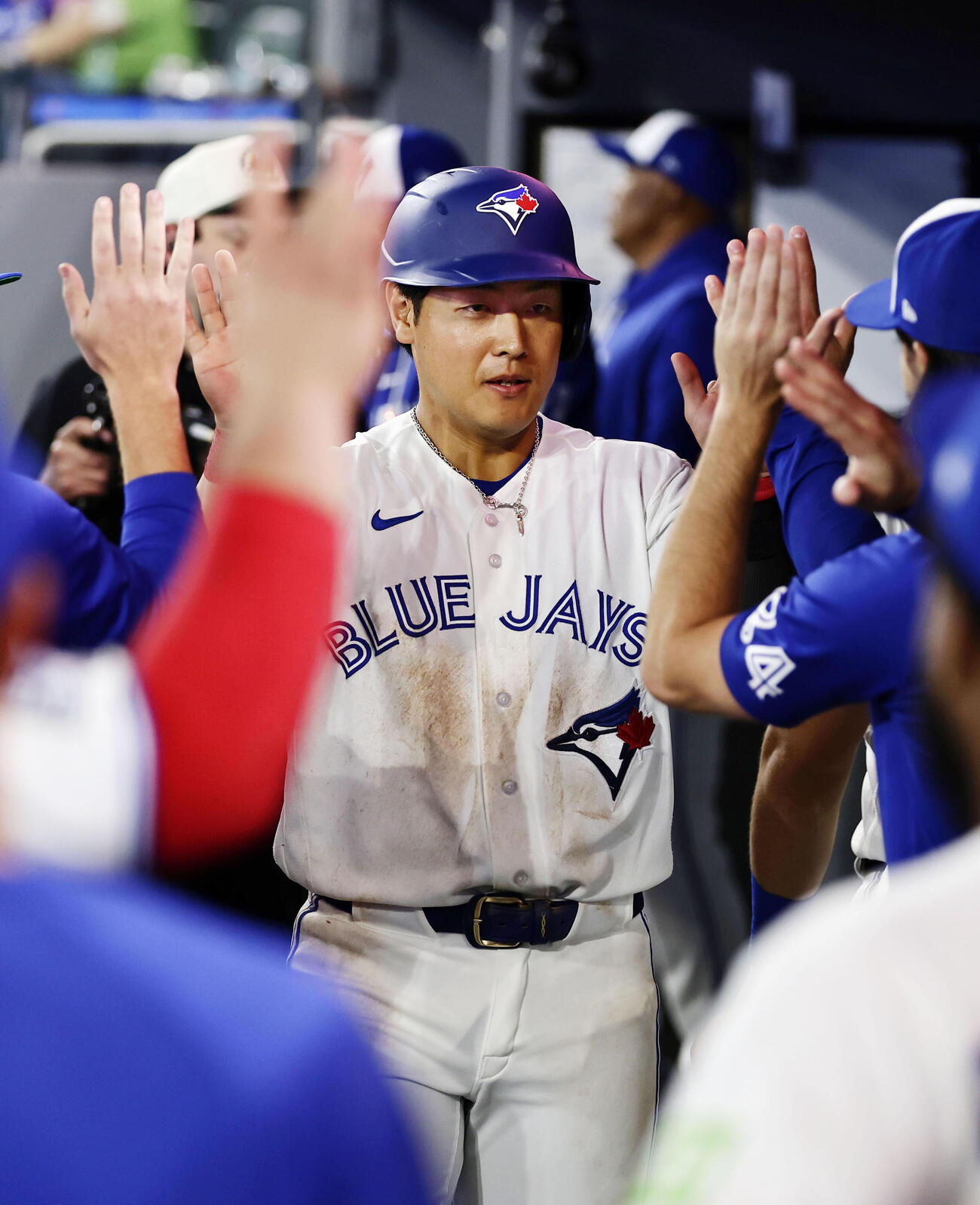 ロッキーズ戦の9回、2号ソロを放ち、迎えられるブルージェイズ・岡本＝トロント（共同）