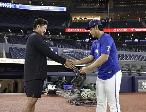 試合前、握手を交わすブルージェイズ・岡本（右）とロッキーズ・菅野＝トロント（共同）