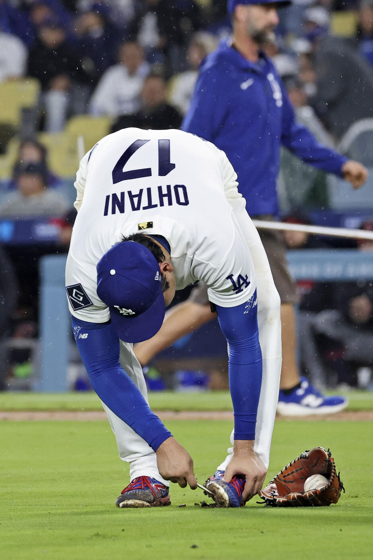 ガーディアンズ戦の6回、スパイクの泥を落とすドジャース大谷（共同）
