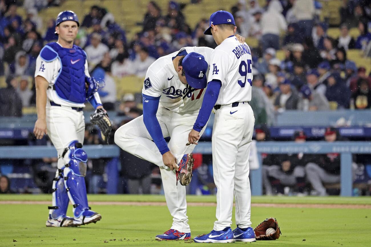 ガーディアンズ戦の6回、スパイクの泥を落とすドジャース大谷（共同）