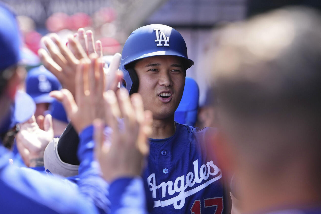 米大リーグ、ナショナルズ戦の3回、今季初本塁打となる3ランを放ちベンチで祝福されるドジャースの大谷翔平（共同）