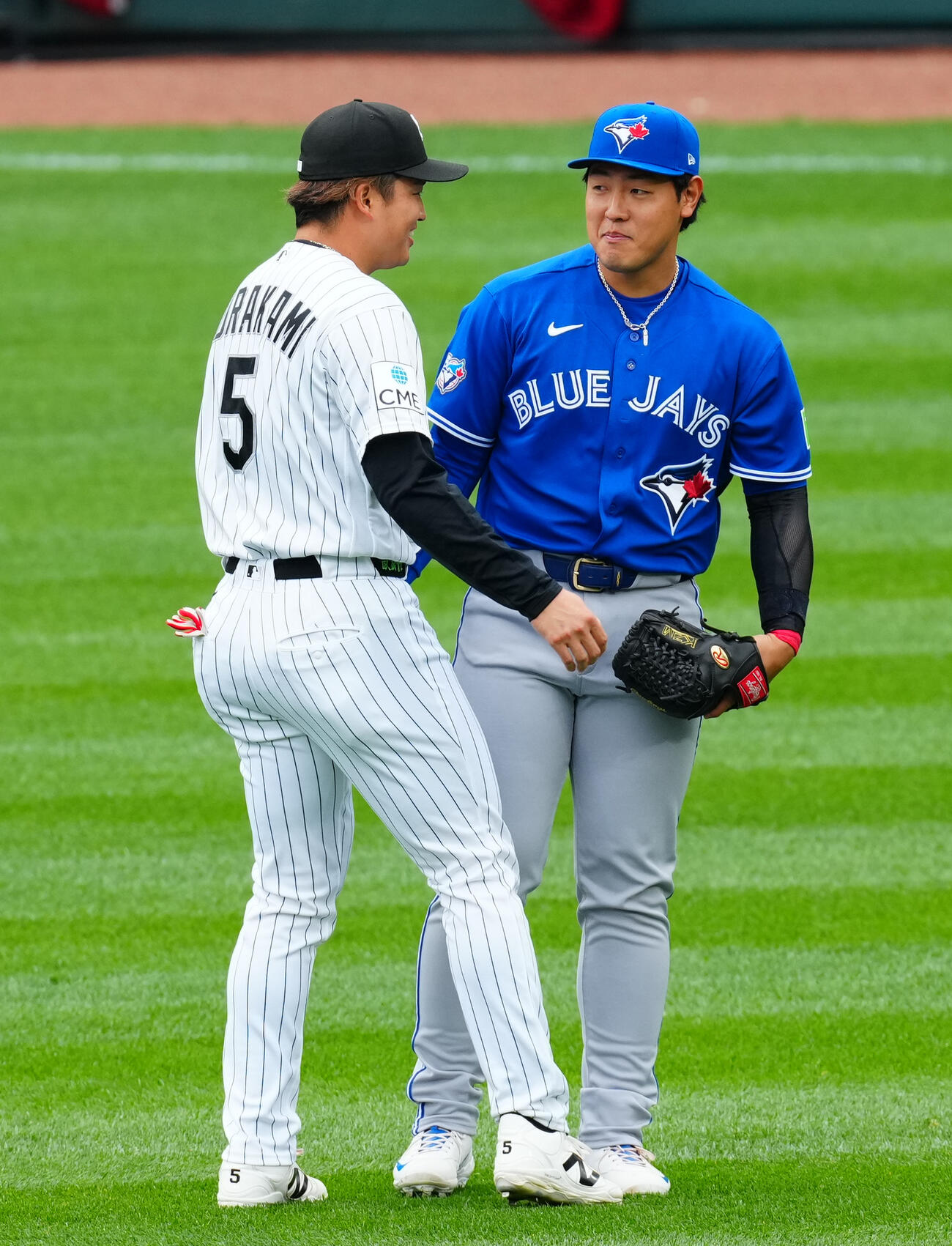 ホワイトソックス対ブルージェイズ　　試合前、談笑するブルージェイズ岡本（右）とホワイトソックス村上（撮影・垰建太）