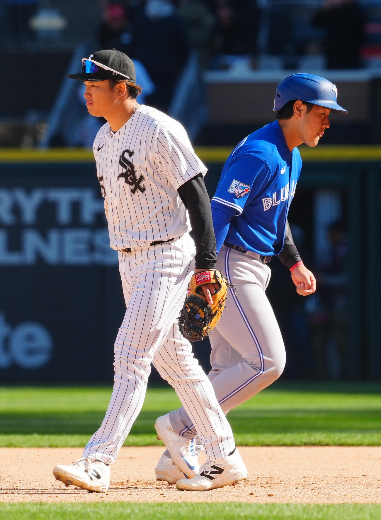 ホワイトソックス対ブルージェイズ　　勝利したホワイトソックス村上（左）と敗れ残塁したブルージェイズ岡本はすれ違う際にタッチを交わし引き揚げる（撮影・垰建太）
