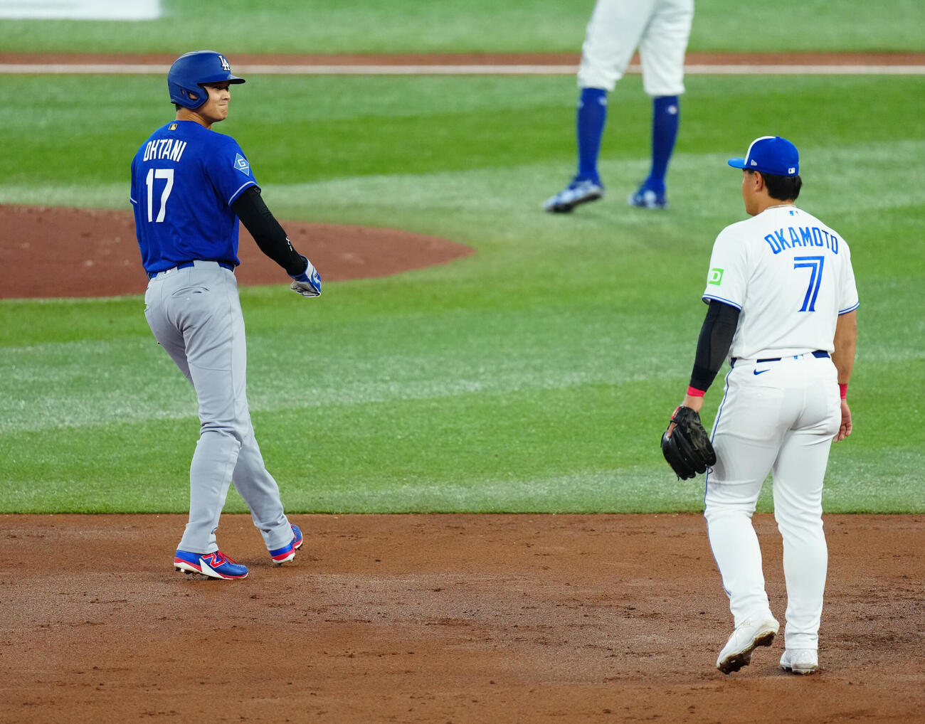 ブルージェイズ対ドジャース　3回表ドジャース無死二塁、走塁の際に三塁手岡本（右）と顔を合わせ笑みを浮かべる大谷（撮影・垰建太）