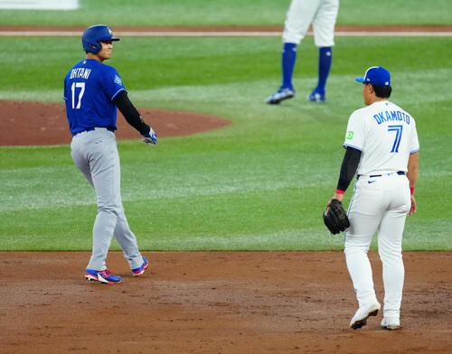 ブルージェイズ対ドジャース 3回表ドジャース無死二塁、走塁の際に三塁手岡本(右)と顔を合わせ笑みを浮かべる大谷(撮影・垰建太)