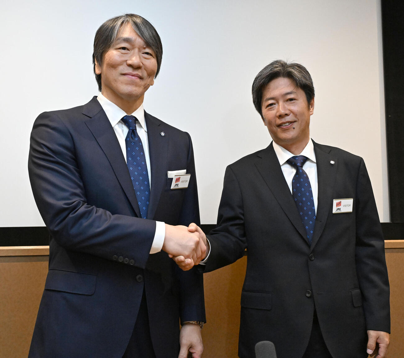 上場セレモニーを終え、握手するヒトトヒトホールディングスの松本社長（右）とアンバサダーを務める松井さん（撮影・千葉一成）