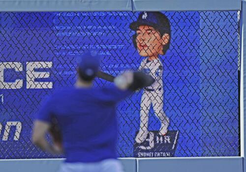 キャッチボールするドジャース大谷(手前)と、自身の首振り人形のモニター(共同)