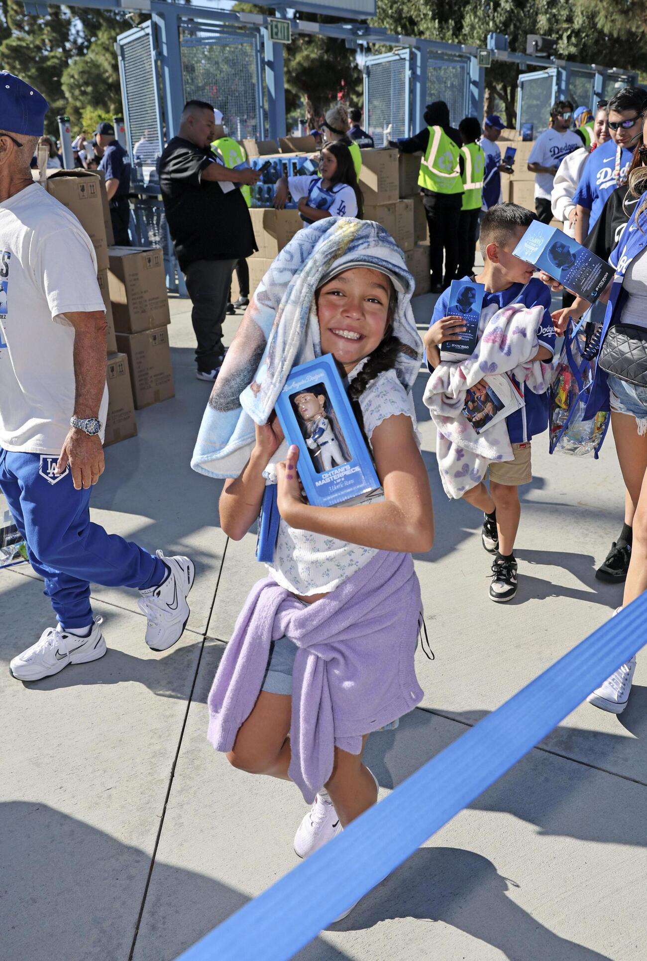 来場者に配られたドジャース・大谷の首振り人形を手に笑顔の子ども＝ロサンゼルス（共同）