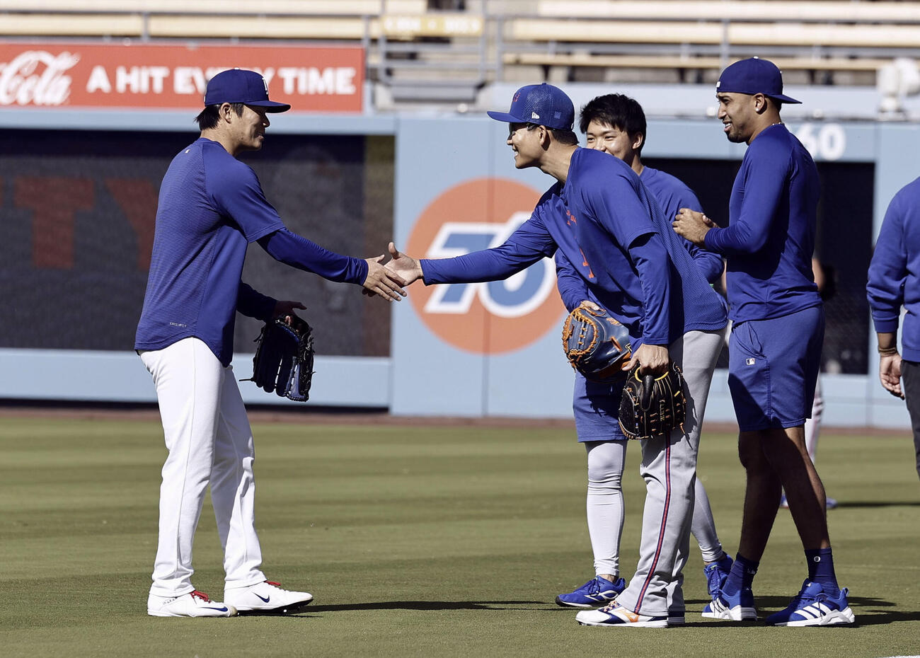 試合前、握手を交わすドジャース・山本（左）とメッツ・千賀。右端はドジャースのディアス＝ロサンゼルス（共同）