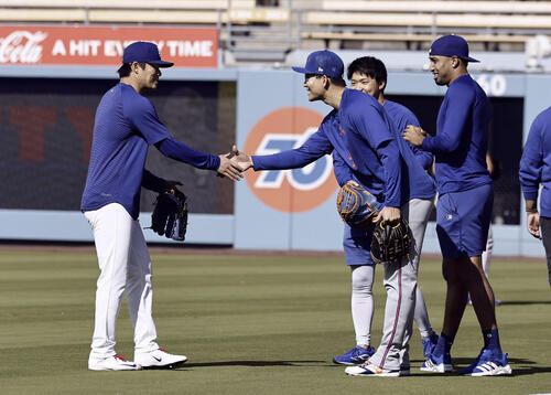 試合前、握手を交わすドジャース・山本(左)とメッツ・千賀。右端はドジャースのディアス=ロサンゼルス(共同)