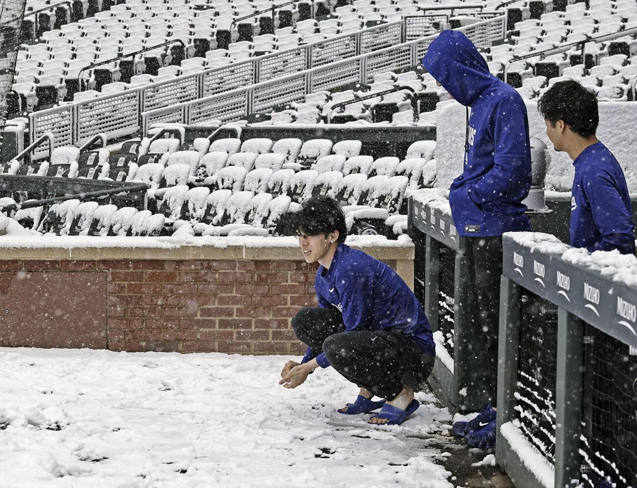 雪が積もったクアーズ・フィールドを見つめるドジャース佐々木（左）＝デンバー（共同）