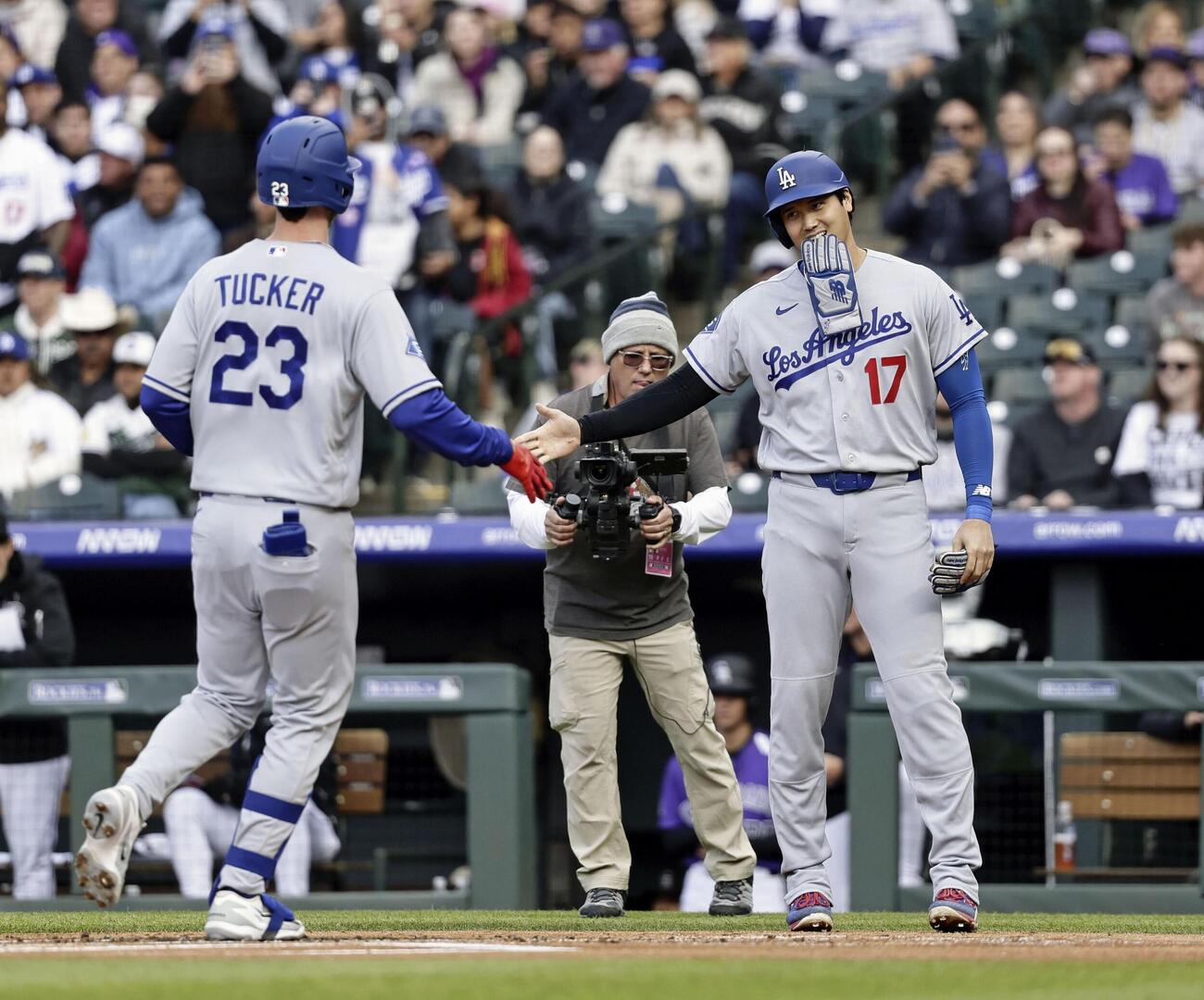 ロッキーズ戦の1回、2ランを放ったタッカー（左）を迎えるドジャース・大谷＝デンバー（共同）
