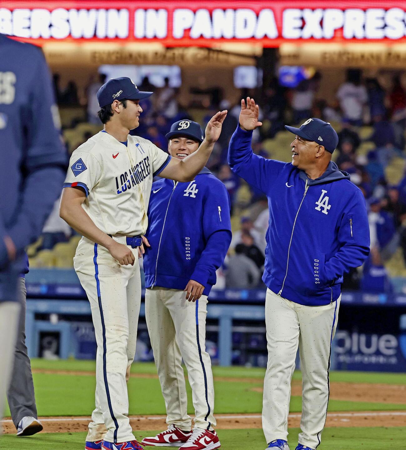 カブスに快勝しロバーツ監督（右）とタッチを交わすドジャース大谷。奥は山本＝ロサンゼルス（共同）