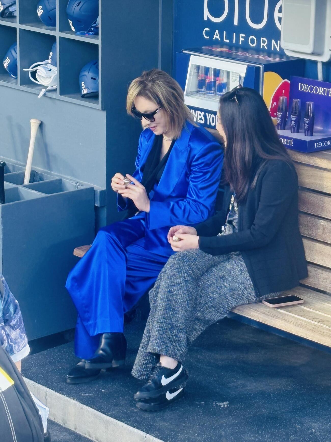 ワールドシリーズのチャンピオンリングを球団職員から披露され手にはめるYOSHIKI（左）