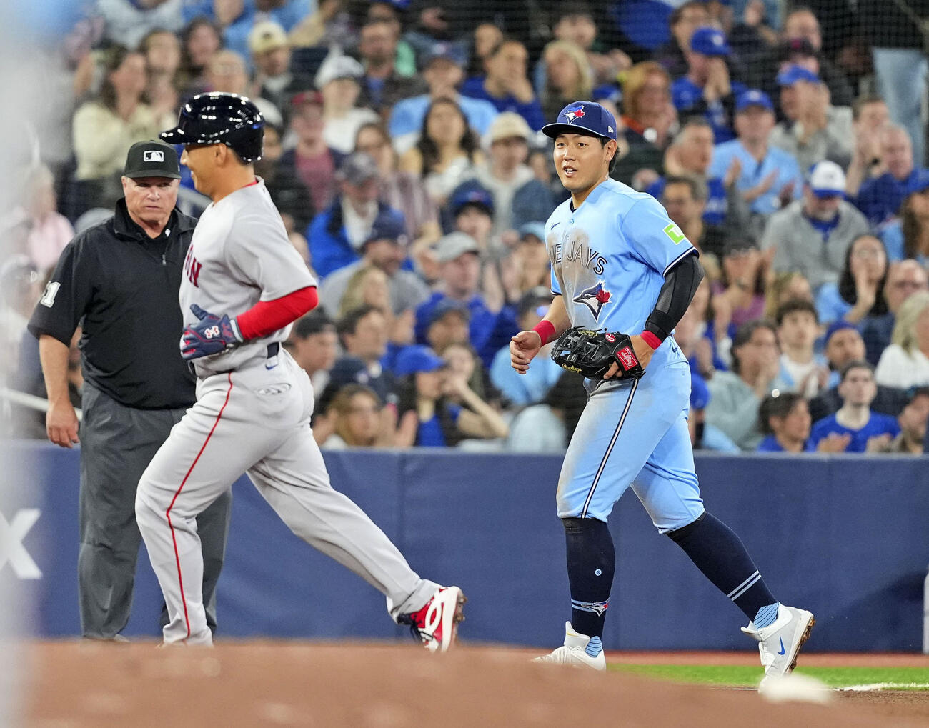 4回、残塁に終わったレッドソックスの一走・吉田（左）と、表情を緩めるブルージェイズの三塁手・岡本＝トロント（共同）