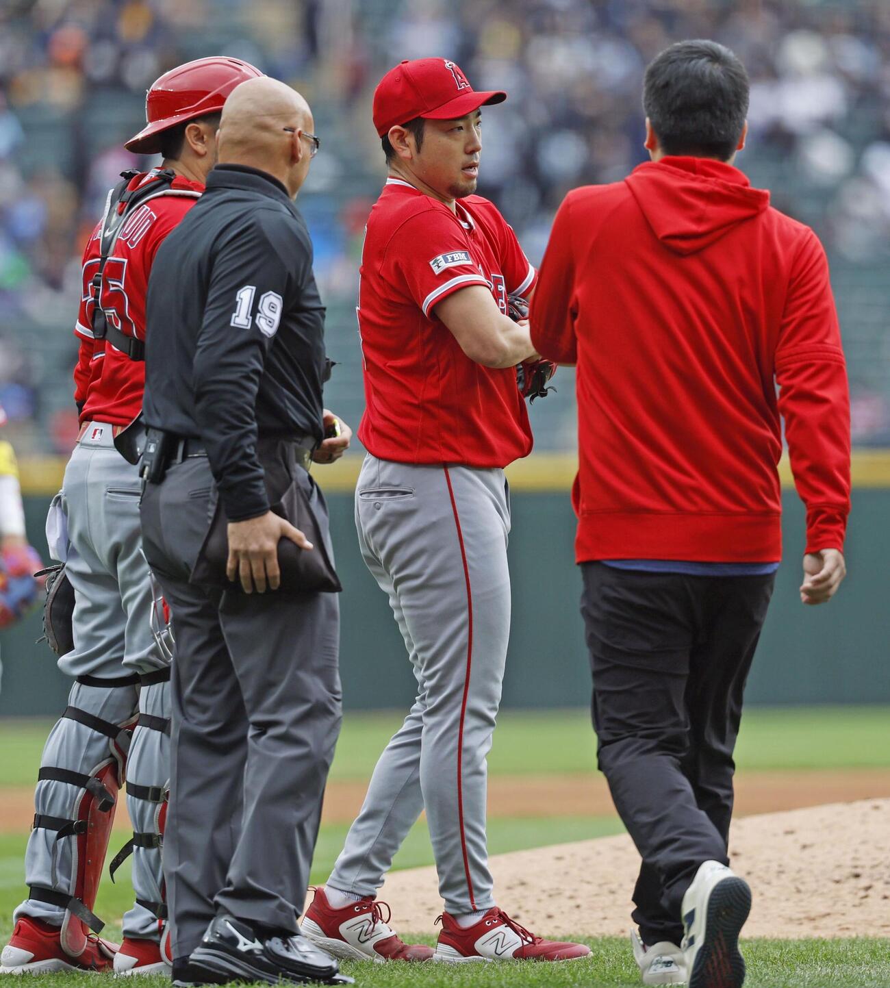 ホワイトソックス戦で、3回のイニング間の投球練習中に左肩の張りを訴えて降板するエンゼルス菊池＝シカゴ（共同）