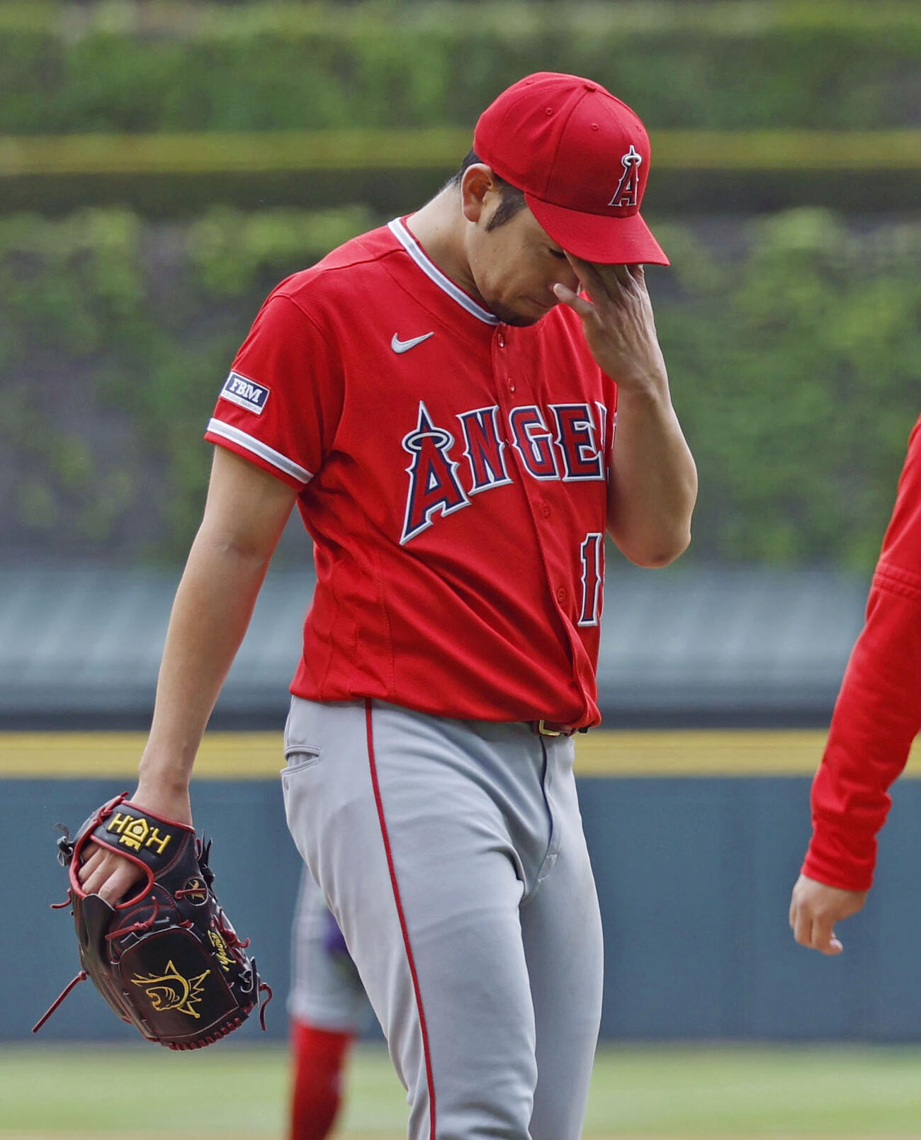 ホワイトソックス戦で、3回のイニング間の投球練習中に左肩の張りを訴えて降板するエンゼルス菊池＝シカゴ（共同）