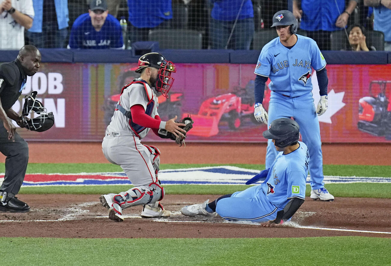 レッドソックス戦の3回、後続の適時打で本塁を狙うがアウトとなるブルージェイズの二走岡本（手前右）＝トロント（共同）