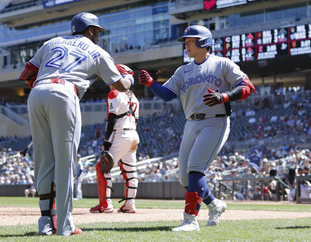 ツインズ戦の9回、3試合連続の本塁打となる9号2ランを放ち迎えられるブルージェイズ岡本（右）＝ミネアポリス（AP＝共同）