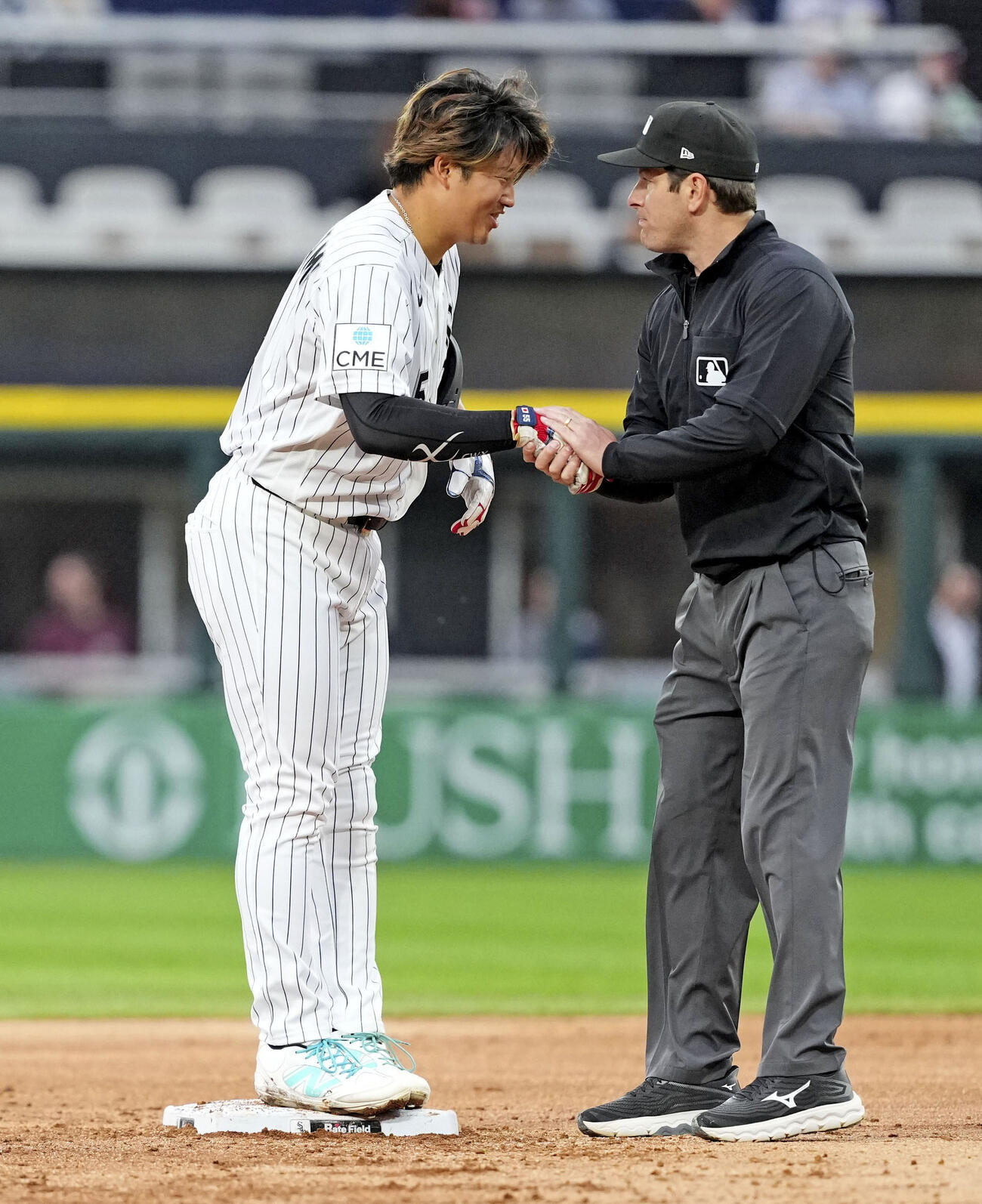 ロイヤルズ戦の3回、後続の四球で二進し塁審に握手であいさつするホワイトソックスの一走村上＝シカゴ（共同）