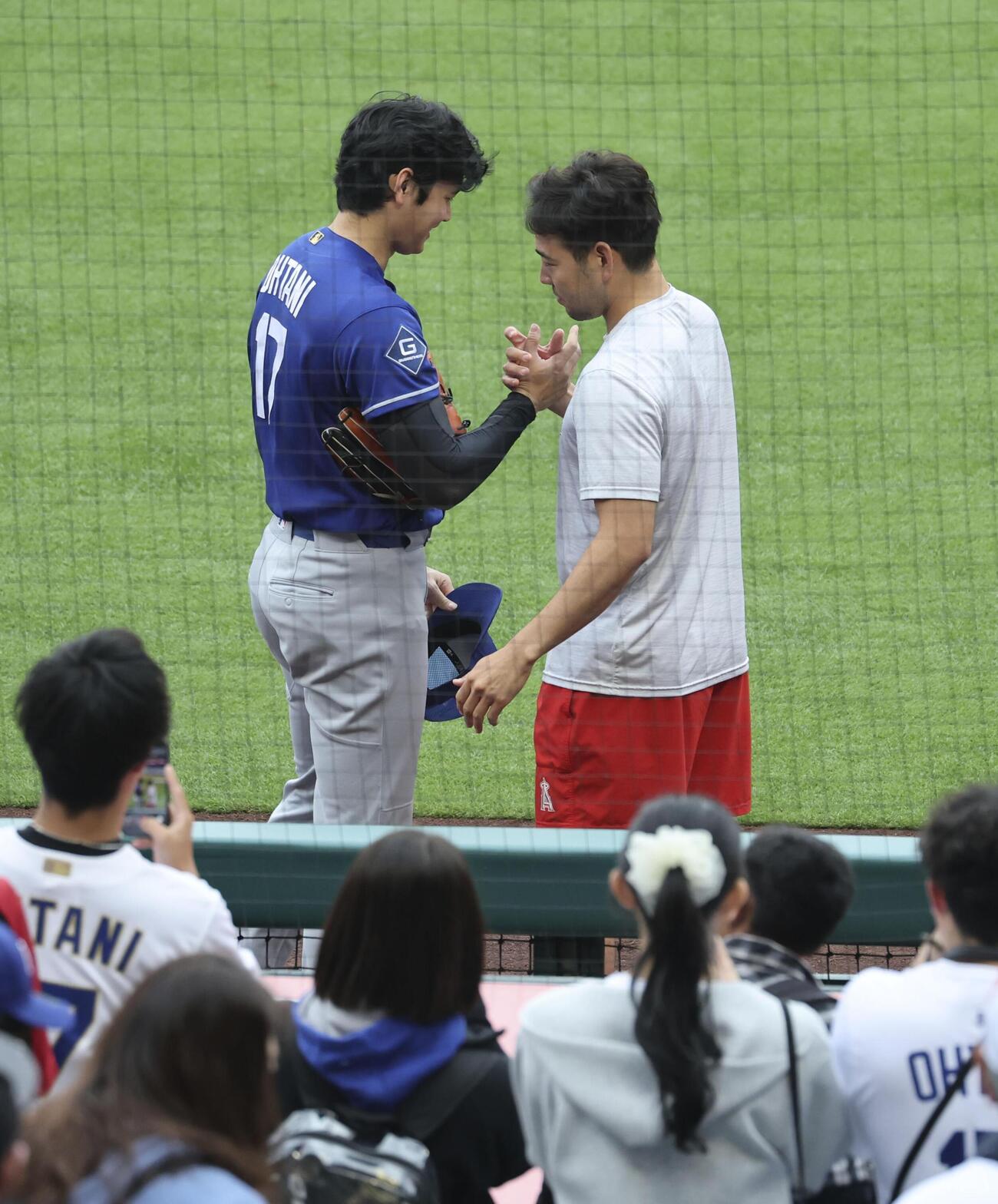 試合前にあいさつするドジャース大谷（左）とエンゼルス菊池（共同）