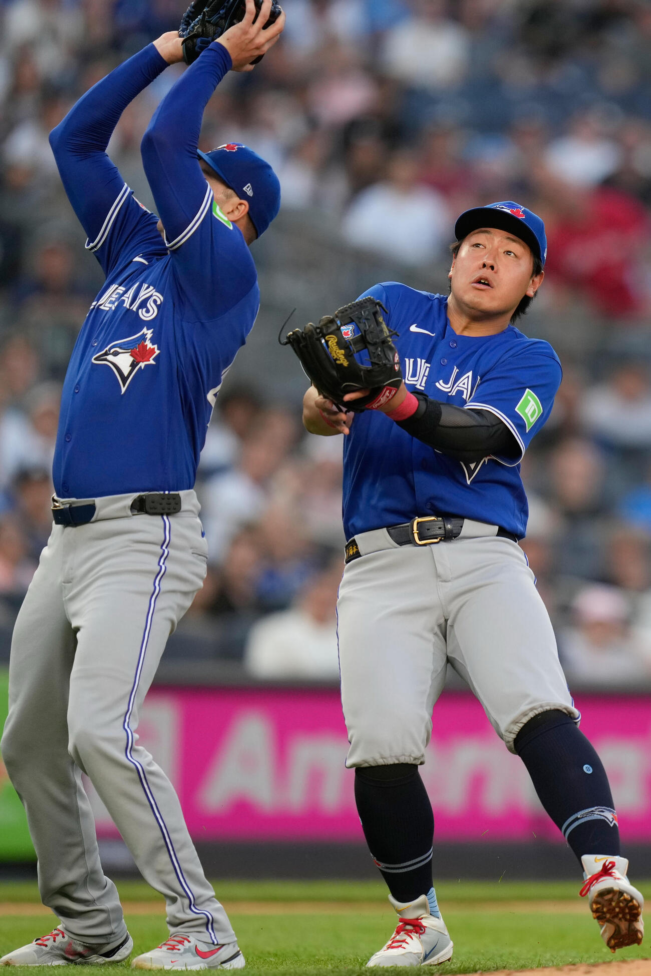 ヤンキース戦の初回、飛球を捕ろうとして投手のコービンとぶつかりそうになるブルージェイズ岡本和真（AP）