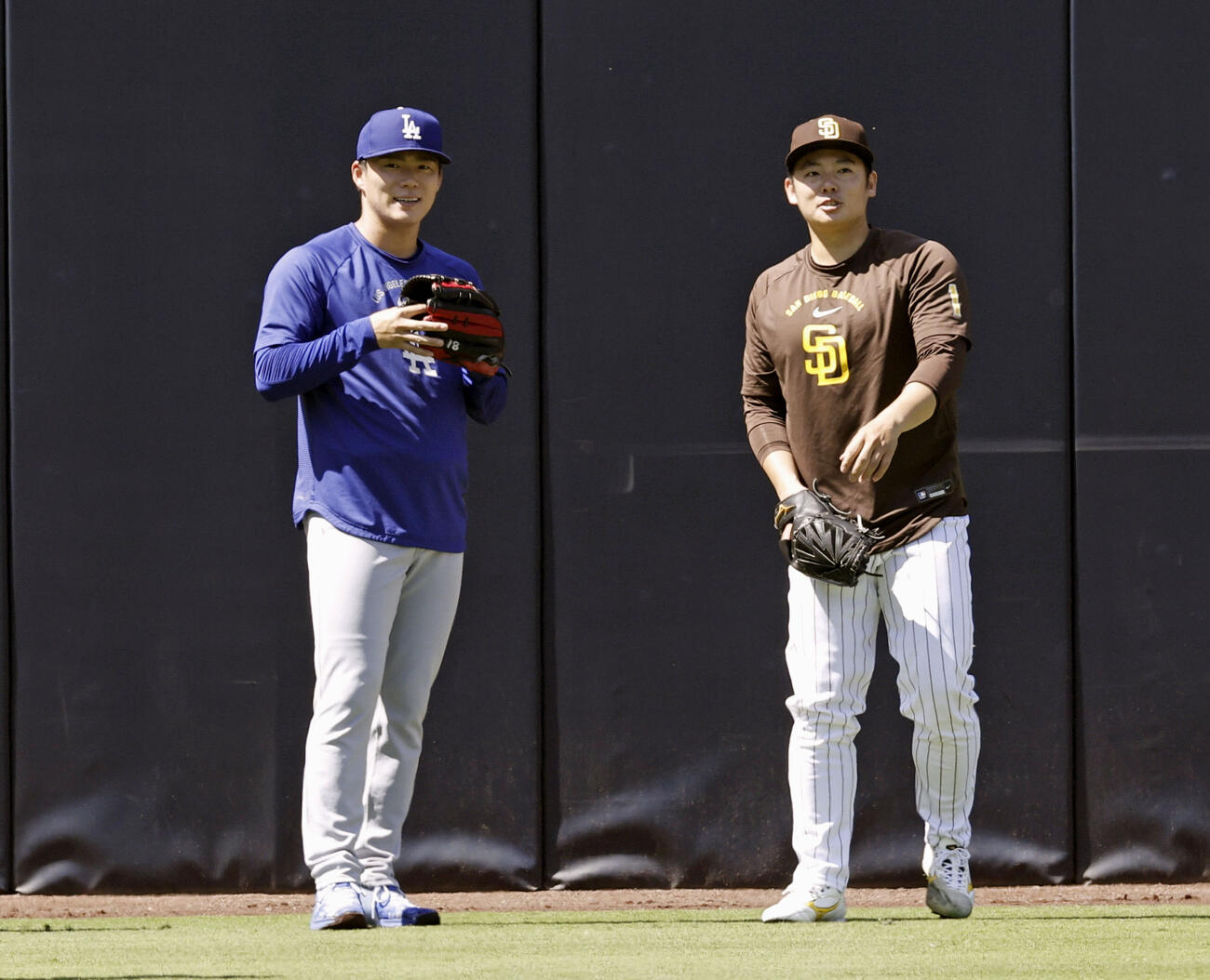 試合前に言葉を交わすドジャース山本（左）とパドレス松井（共同）