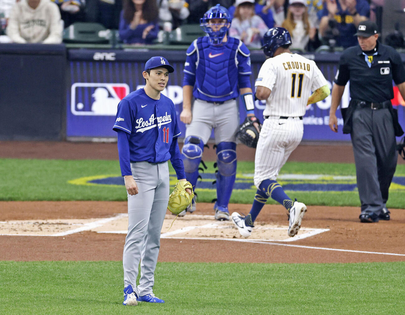 ブルワーズ戦の1回、先制二塁打を許したドジャース佐々木。左から3人目は生還するチョウリオ（共同）