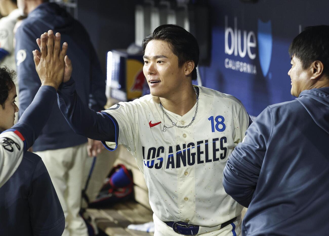 エンゼルス戦の8回を投げ終え、ベンチでタッチを交わすドジャース山本。8回1失点の好投で6勝目を挙げた（共同）