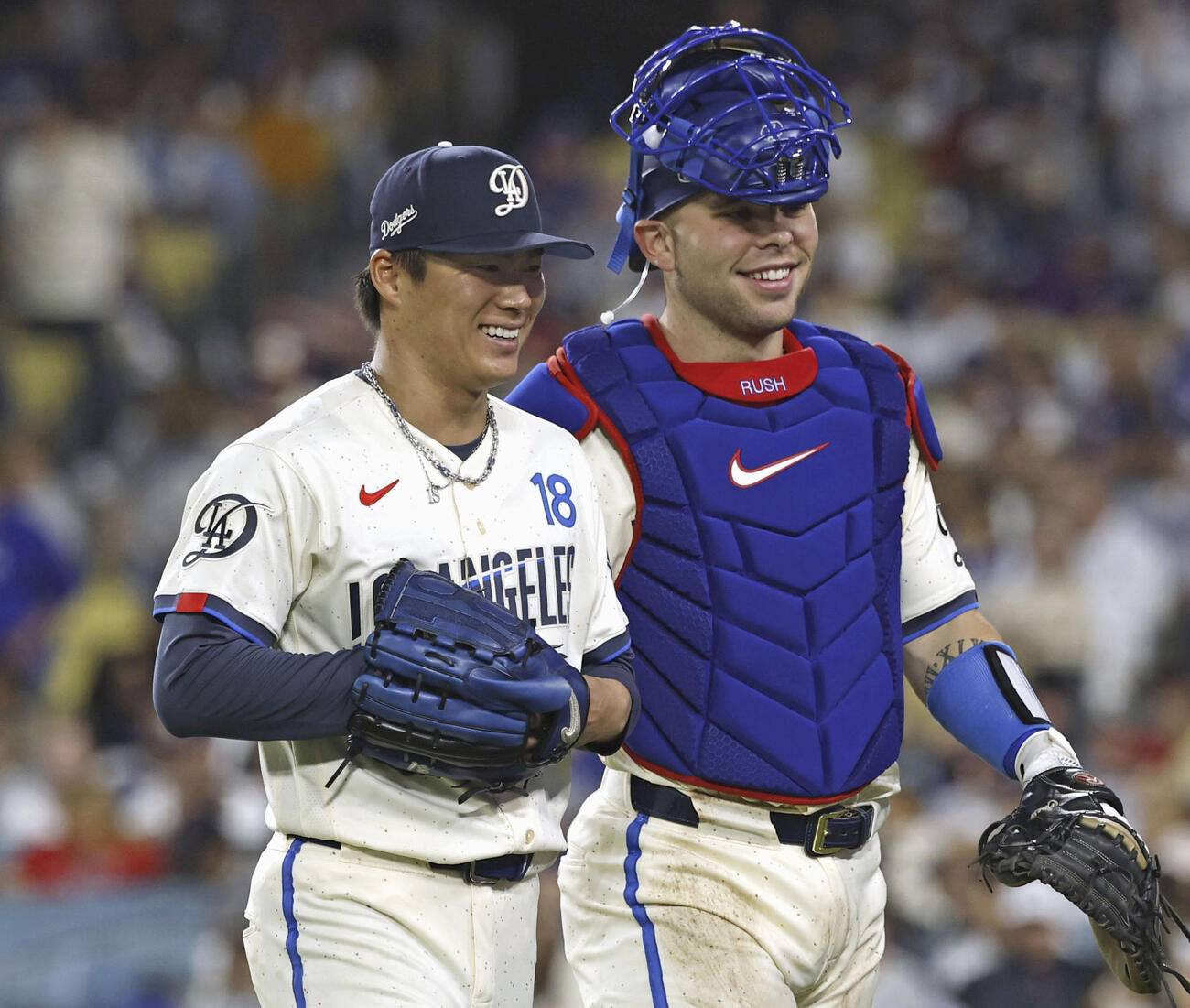 エンゼルス戦の7回を投げ終え、笑顔でベンチに戻るドジャース山本（左）と捕手ラッシング（共同）