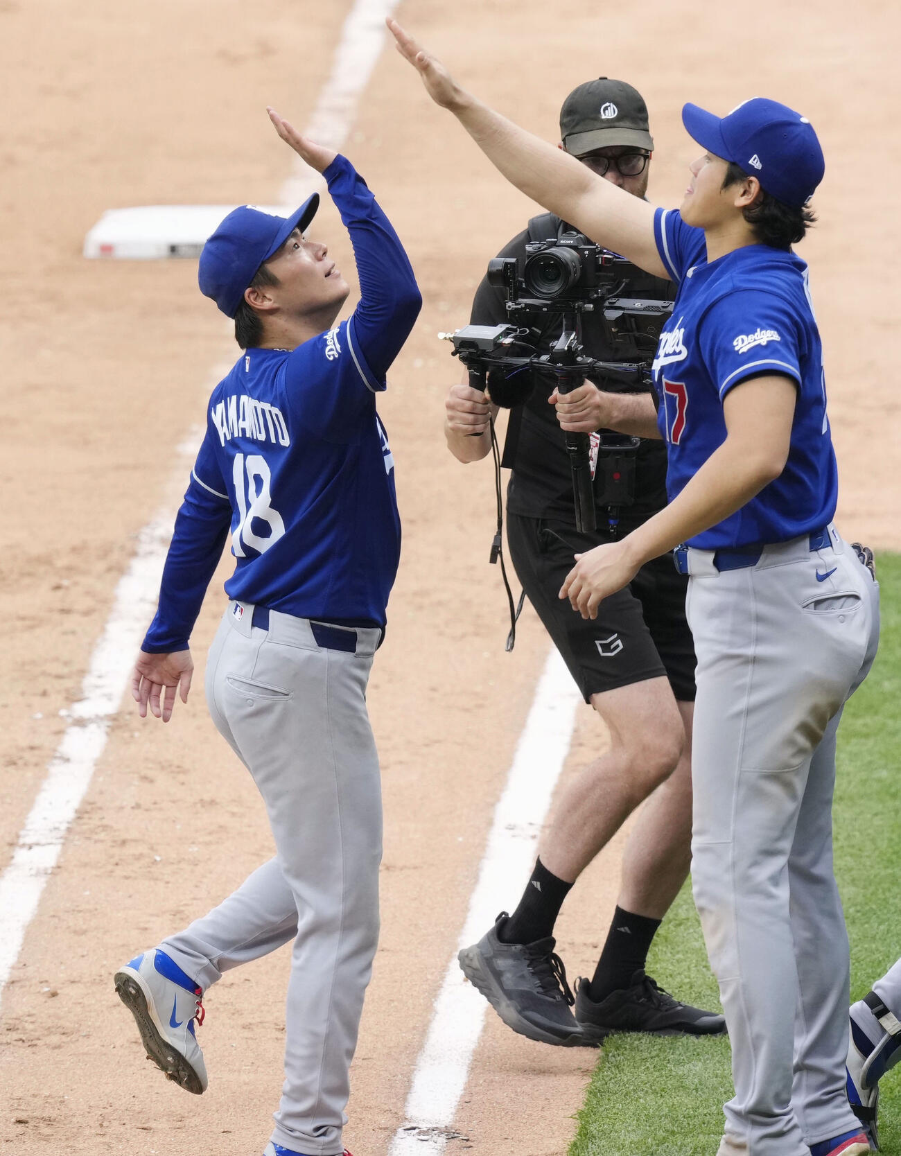 ホワイトソックスに勝利し、ハイタッチで喜ぶドジャース山本（左）と大谷（共同）