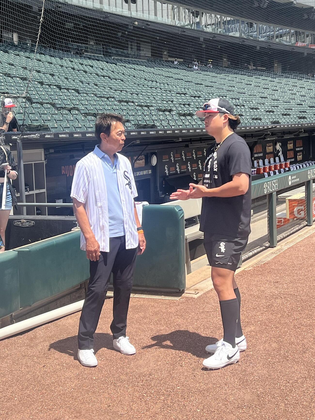 試合前、ヤクルト時代の恩師小川淳司氏（左）から激励される村上