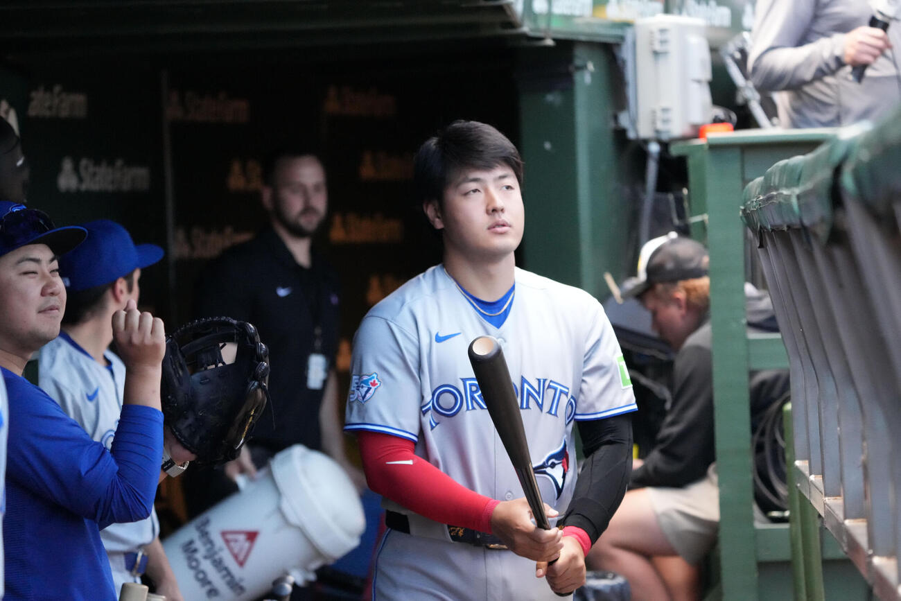 試合開始前、ベンチでバットを持つブルージェイズ岡本和真（AP）