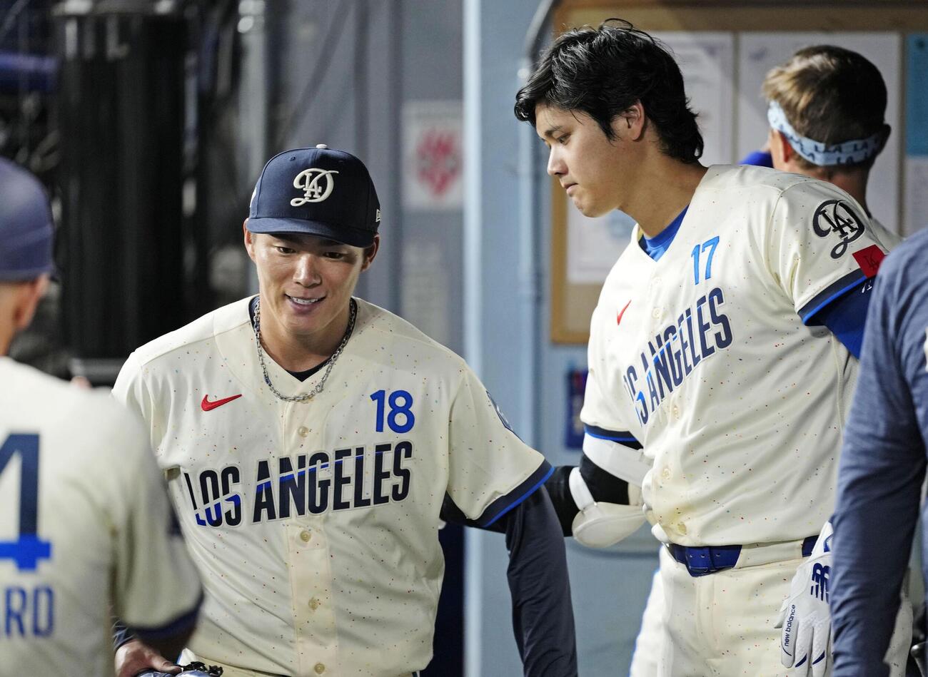 オリオールズ戦の6回を投げ終えた山本（左）をベンチで迎えるドジャース大谷（共同）