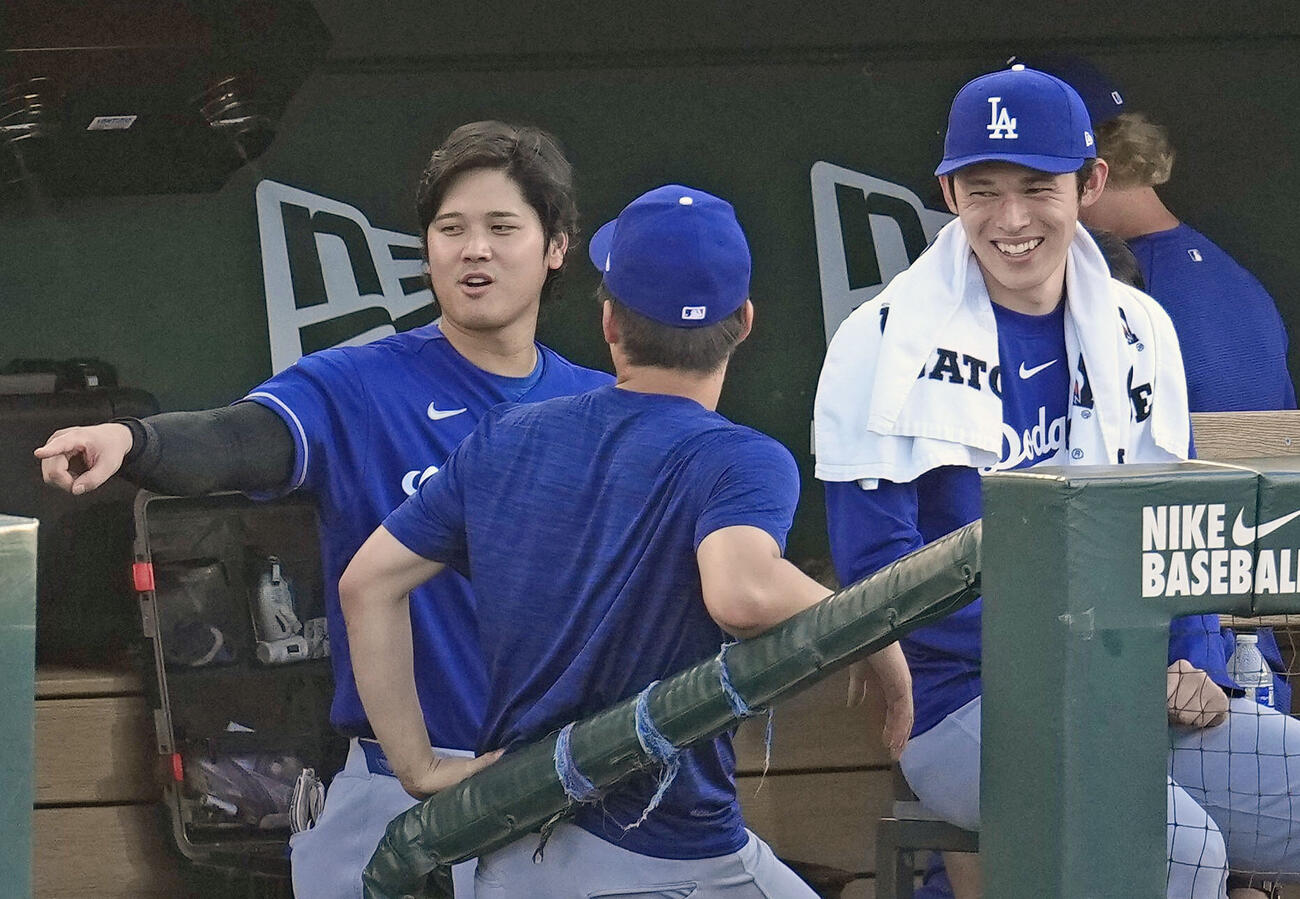 アスレチックス戦の1回、ベンチで言葉を交わすドジャース大谷（左）と佐々木（右）ら（共同）