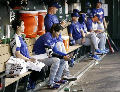 アスレチックス戦の6回、ベンチでタブレット端末を見るドジャース・大谷（左から2人目）＝サクラメント（共同）