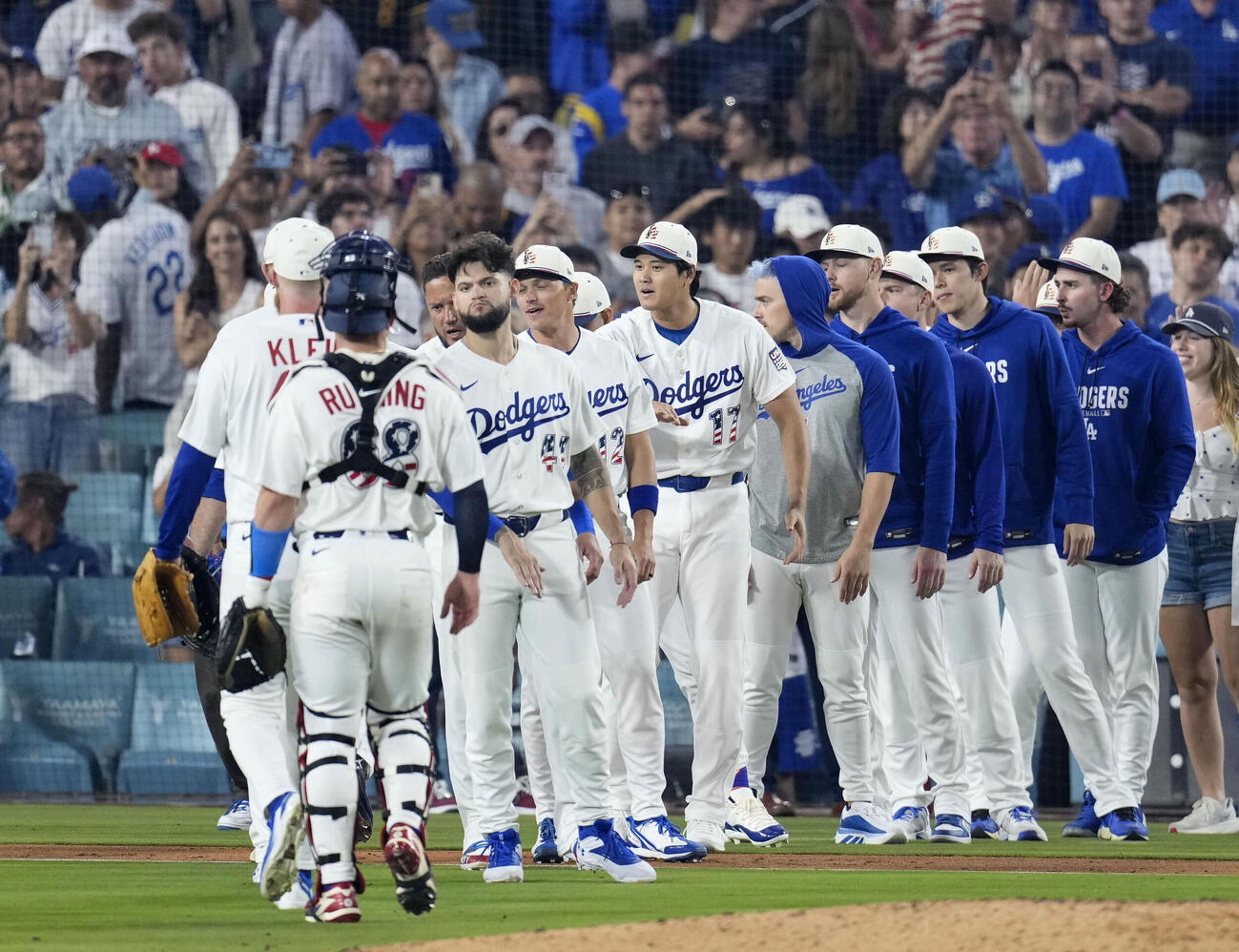 パドレスに勝利し、チームメートとタッチを交わすドジャース・大谷（中央、17）＝ロサンゼルス（共同）