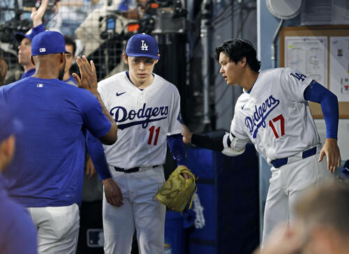 ロッキーズ戦の4回を終え、ベンチに戻った佐々木(中央)を迎えるドジャース・大谷=ロサンゼルス(共同)