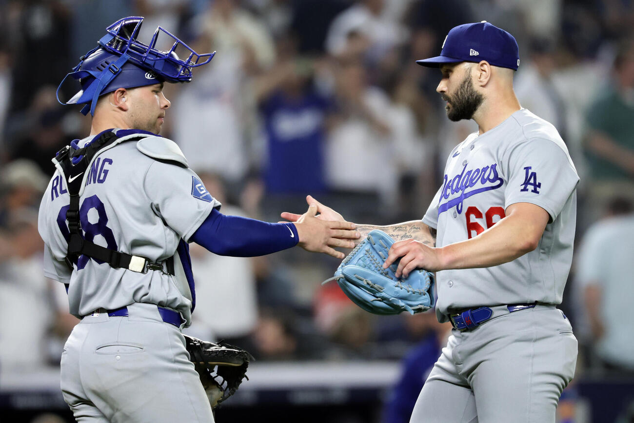 試合を締めくくりラッシング（左）とタッチを交わすスコット（AP）