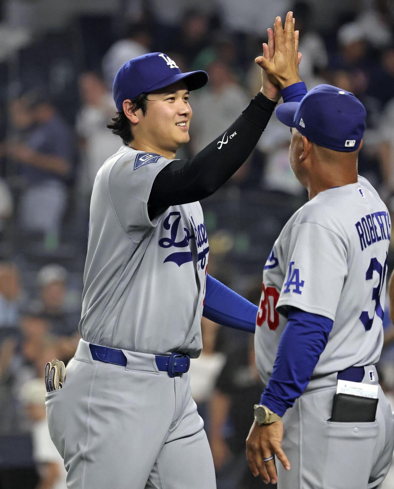 ヤンキースに勝利しロバーツ監督とタッチするドジャース・大谷（共同）