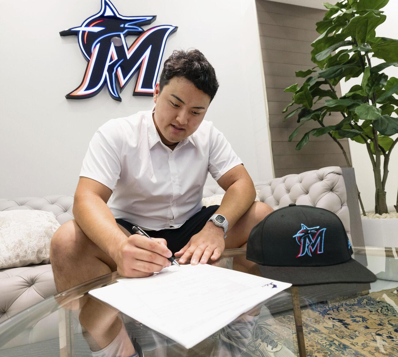 マーリンズとの契約書にサインする佐々木麟太郎（7月20日撮影）（球団提供・共同）