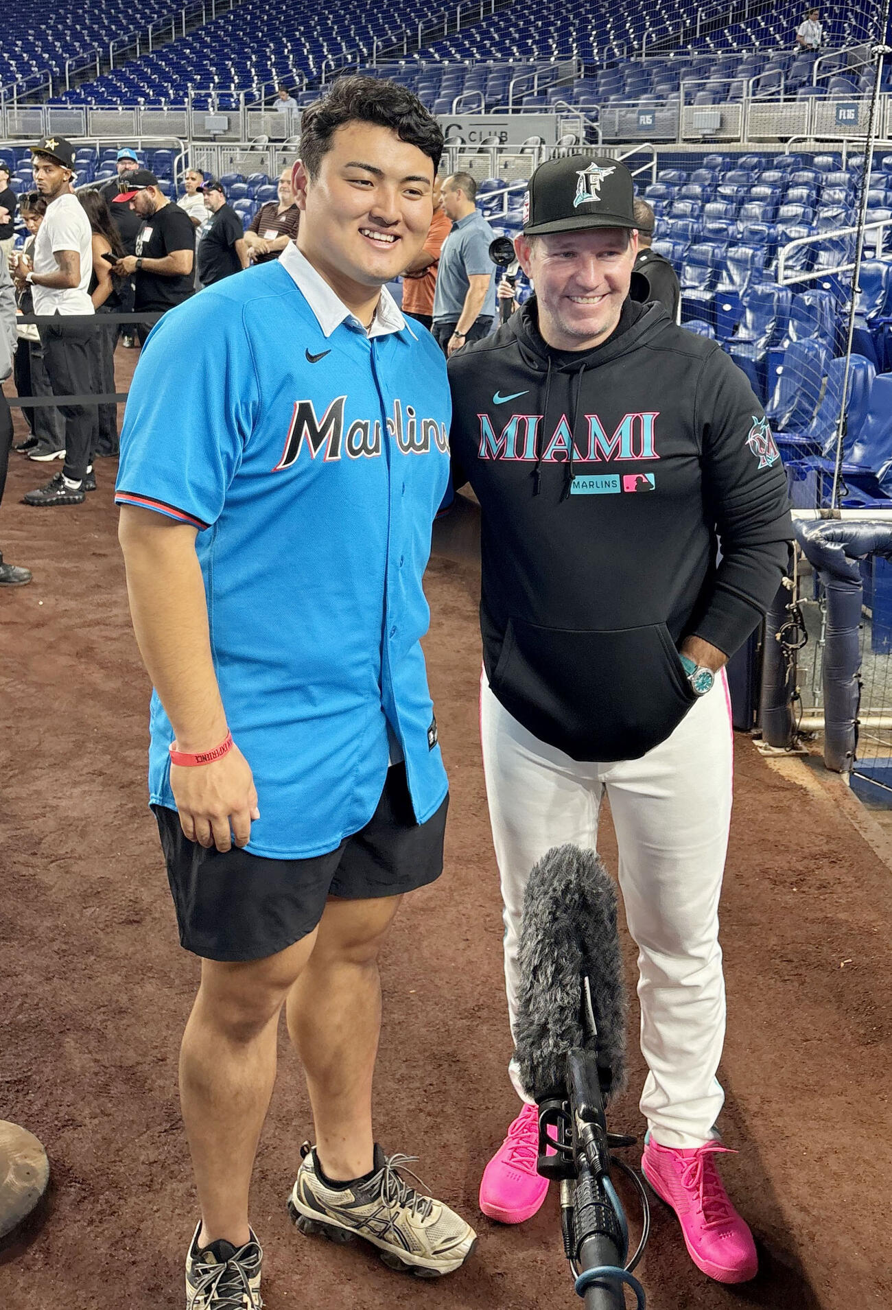 試合前練習を見学し、マーリンズのマッカラー監督（右）と撮影に応じる佐々木麟太郎（共同）