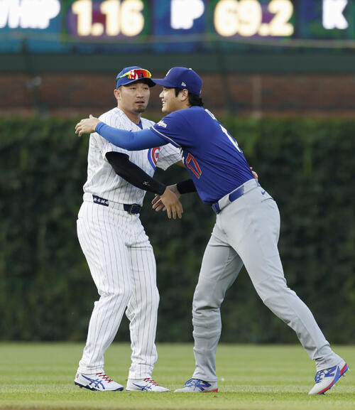 試合前、カブス・鈴木(左)と握手するドジャース・大谷=シカゴ(共同)