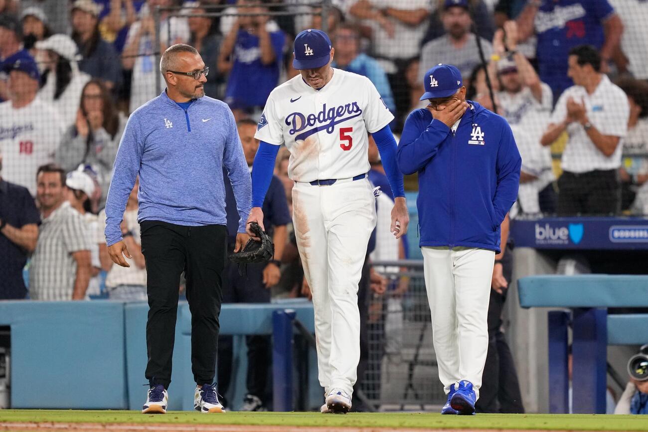 ロバーツ監督らに付き添われ、グラウンドに戻るドジャース・フリーマン（AP）