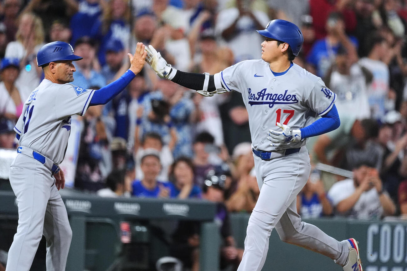 ロッキーズ対ドジャース　5回表、菅野から28号本塁打を放ち、3塁コーチとハイタッチをする大谷翔平（AP）