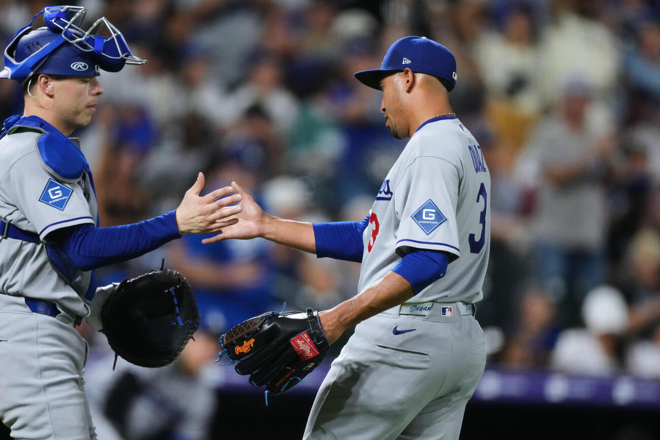 ロッキーズに勝利し、ドジャースのフェドゥシア捕手（左）と握手するディアス（AP）