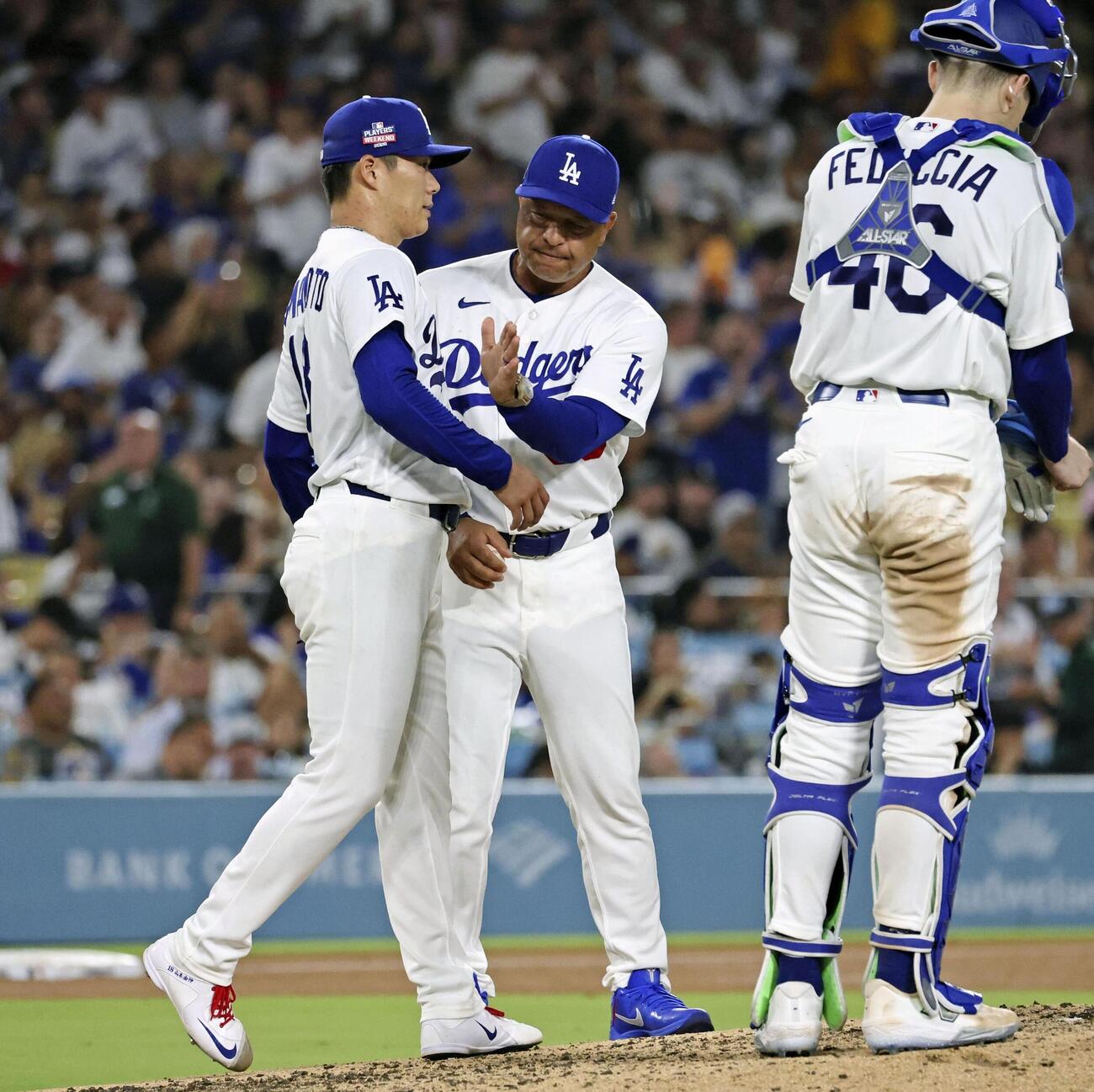 パイレーツ戦の7回途中、ロバーツ監督（中央）に降板を告げられるドジャース・山本（左）＝ロサンゼルス（共同）