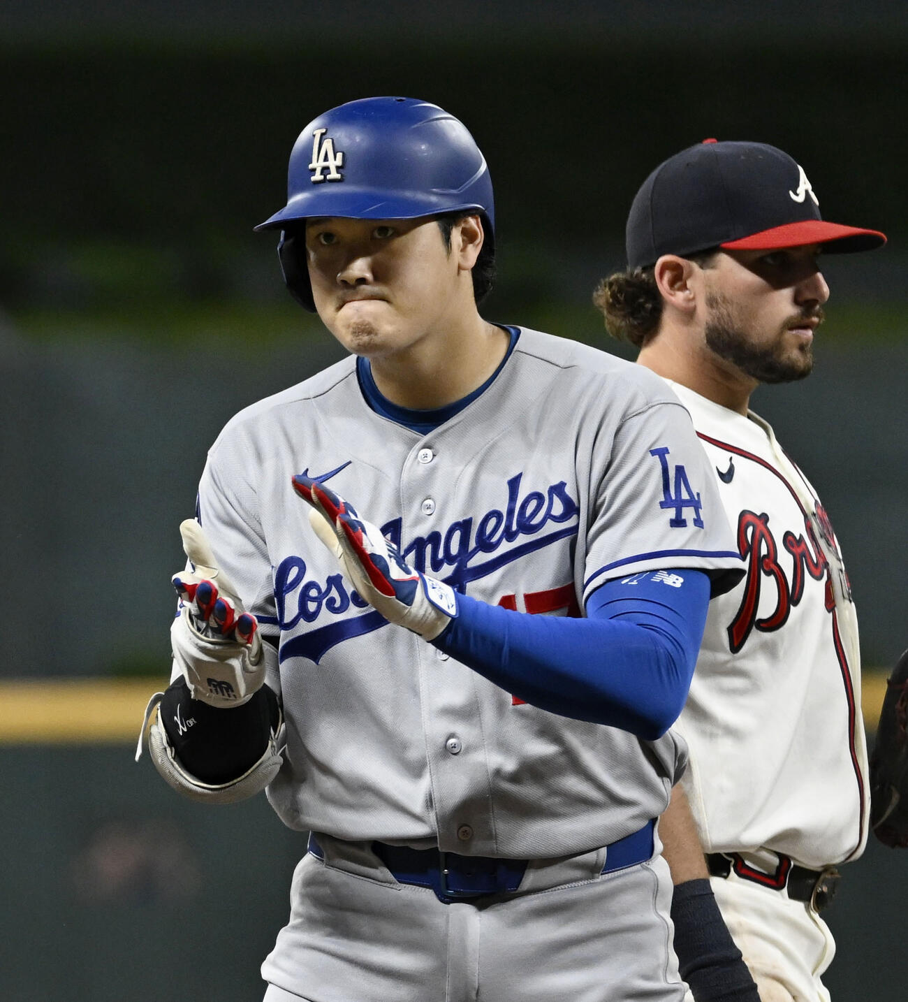 ブレーブス戦の9回、三塁打を放ち塁上で手をたたくドジャース・大谷（左）＝アトランタ（共同）